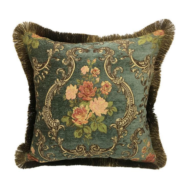 a blue pillow with flowers on it and fringe trimmings around the edges, in front of a white background