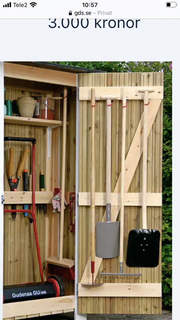 an outdoor storage shed with the door open and tools stored in it's compartment