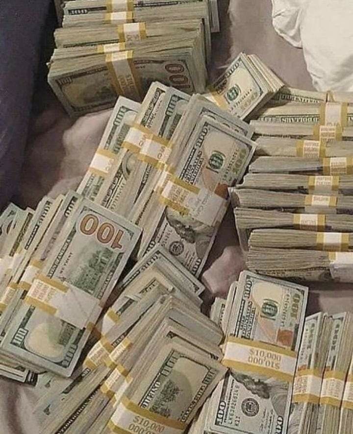 a pile of money sitting on top of a bed