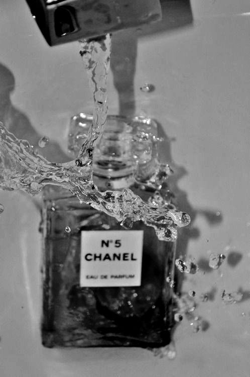 chanel no 5 perfume bottle with water splashing from it, in black and white