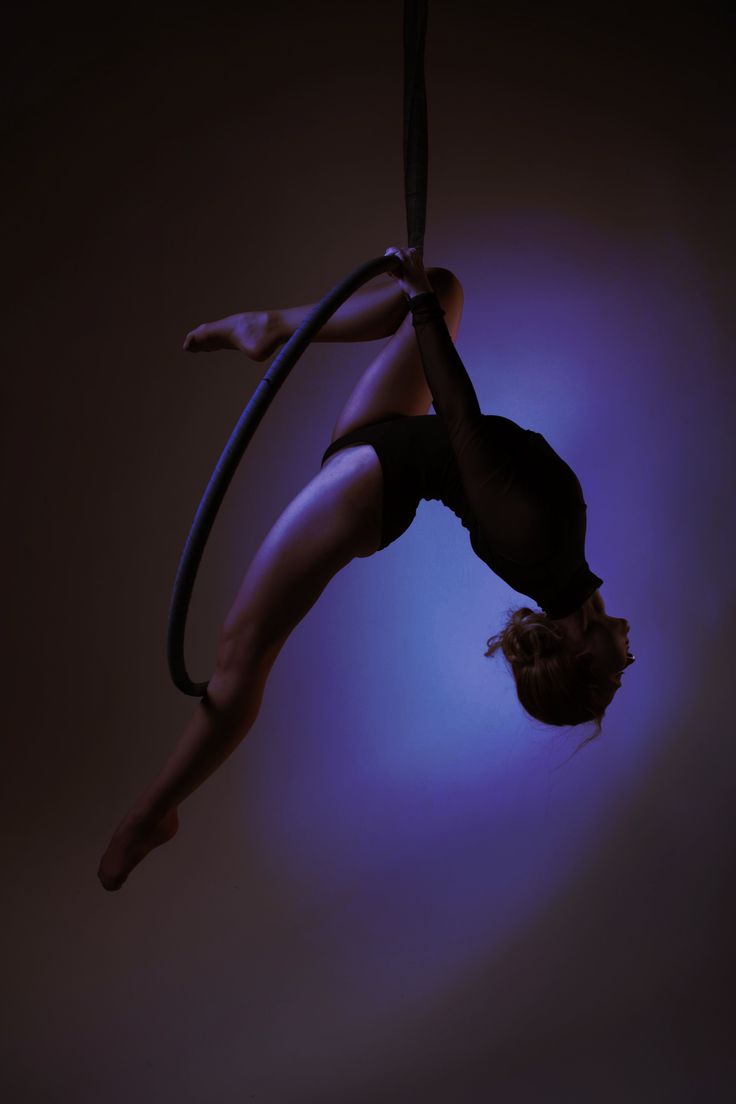 a woman hanging upside down on a rope