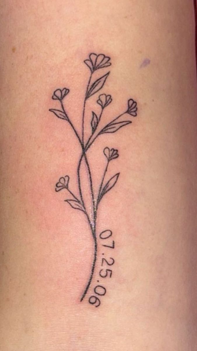 a small tattoo on the side of a woman's leg with flowers in it