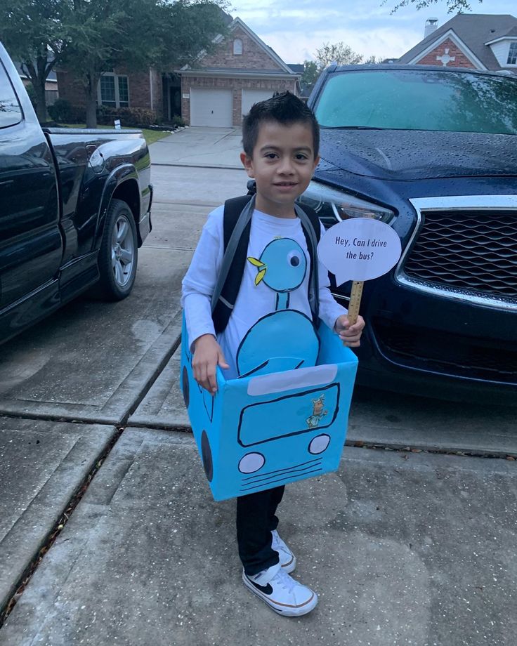 a young boy holding a cardboard box with a blue bird on it and a sign that says i love you