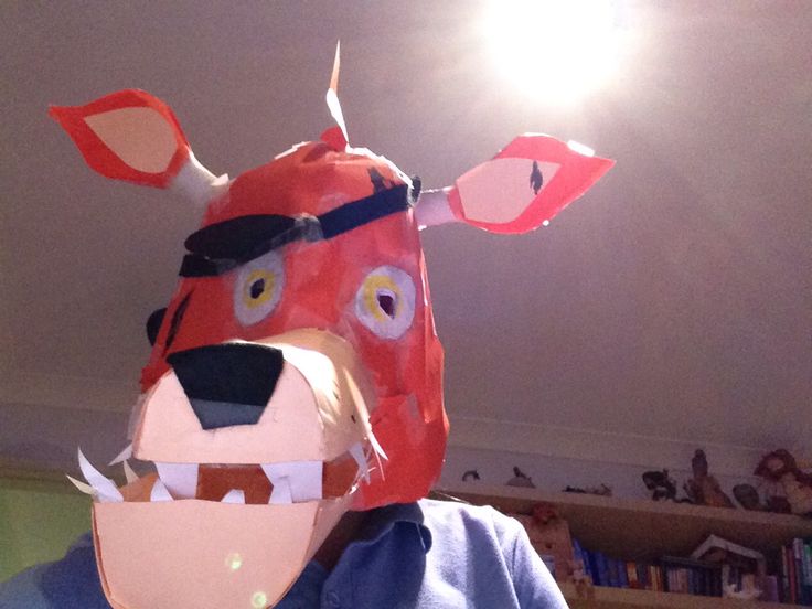 a person wearing a paper animal mask in a room