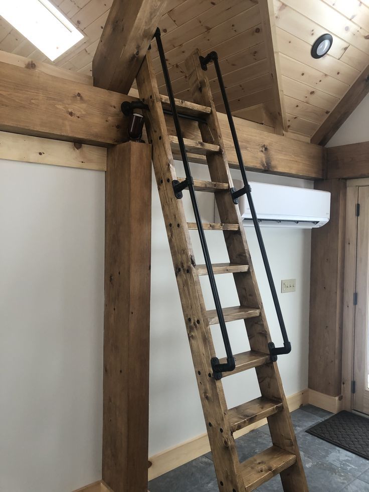 a wooden ladder sitting inside of a room next to a window on top of a carpeted floor