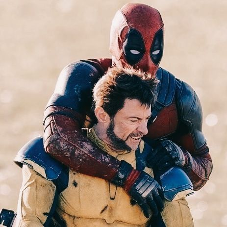 two men dressed as deadpool and spider - man, one carrying the other on his back