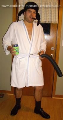 a man in a bathrobe is holding a can and a blow dryer