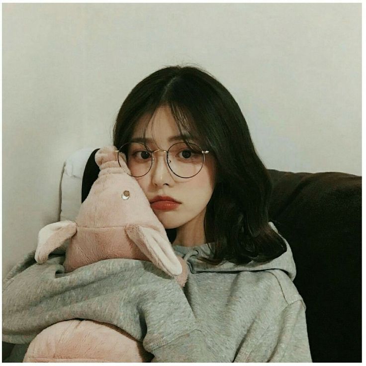 a woman with glasses holding a stuffed animal