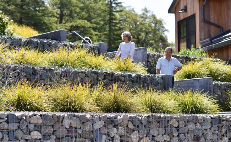 two men are walking up some steps made out of rocks and stones with grass growing on the sides