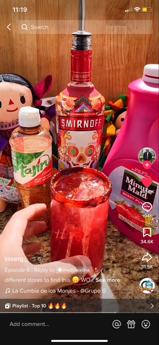 someone is holding a drink in front of some bottles and other items on the counter