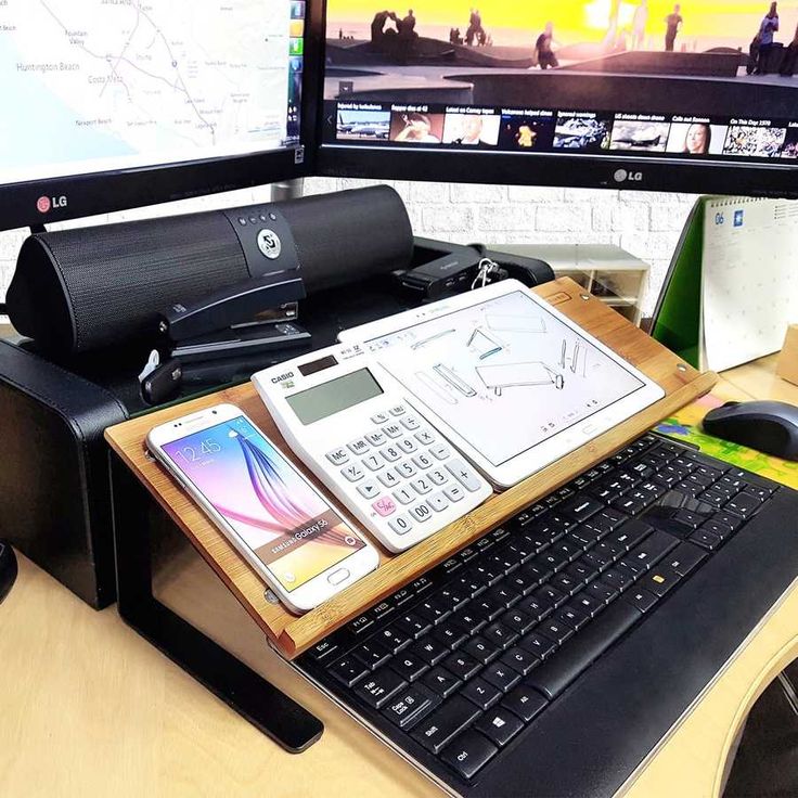 a desk with a phone, cellphone and laptop on it next to a computer monitor