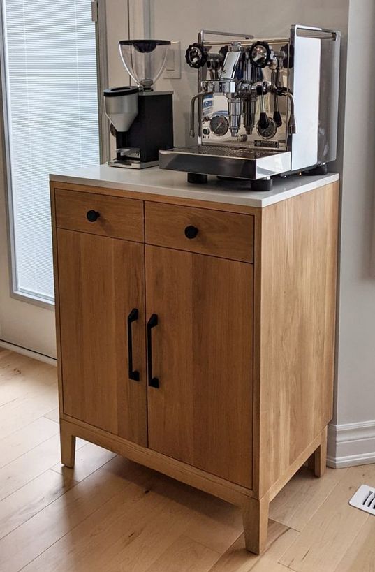 a coffee machine sitting on top of a wooden cabinet