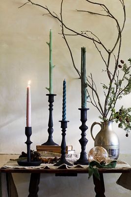 a table topped with candles next to a vase filled with flowers and greenery on top of a wooden table