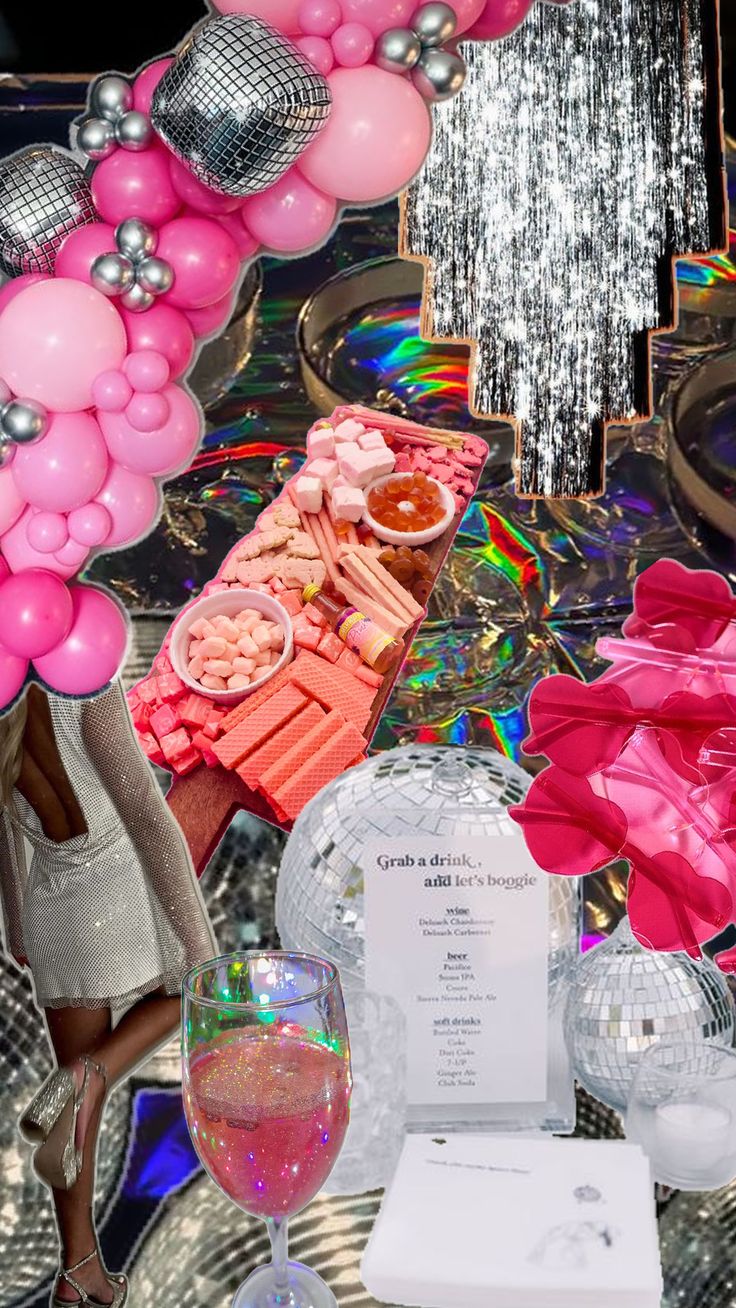 a table topped with lots of pink and silver balloons next to a wine glass filled with champagne