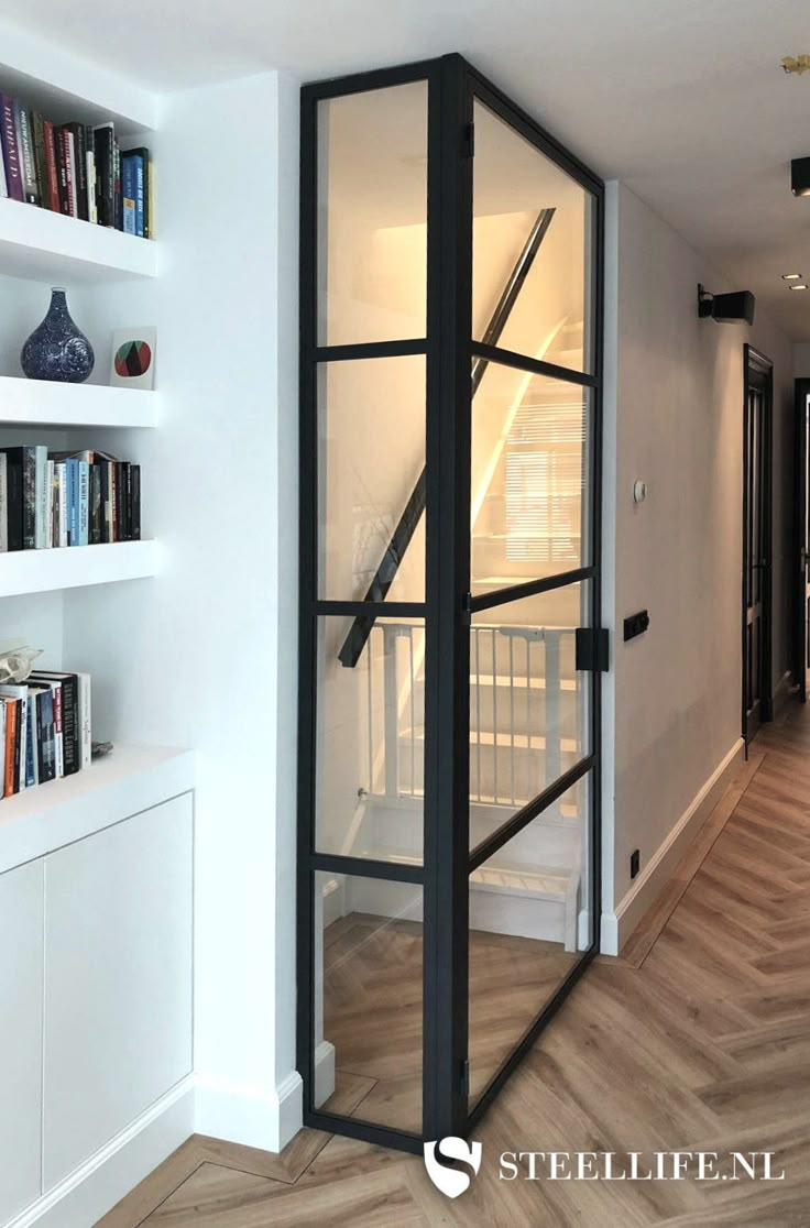 an empty room with bookshelves and shelves on either side of the door that is open