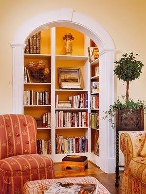 a living room filled with lots of books and furniture