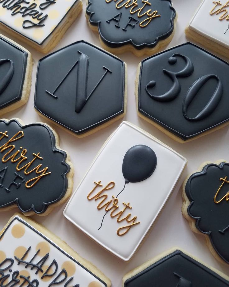 decorated cookies with black and white icing are arranged on a table in the shape of hexagons