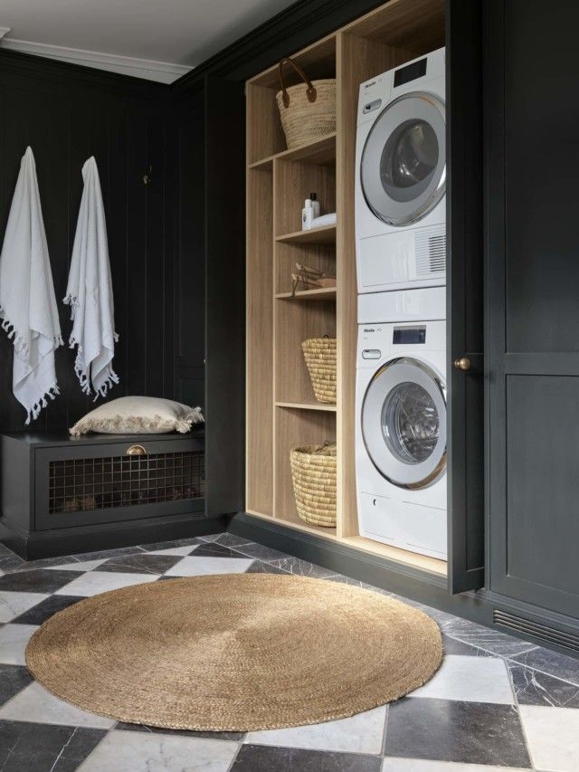 a washer and dryer in a room with black walls, checkered flooring