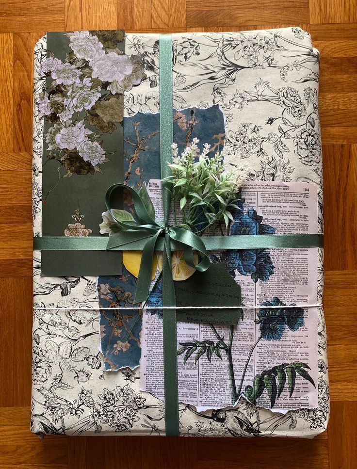 a wrapped present with flowers and greenery on it