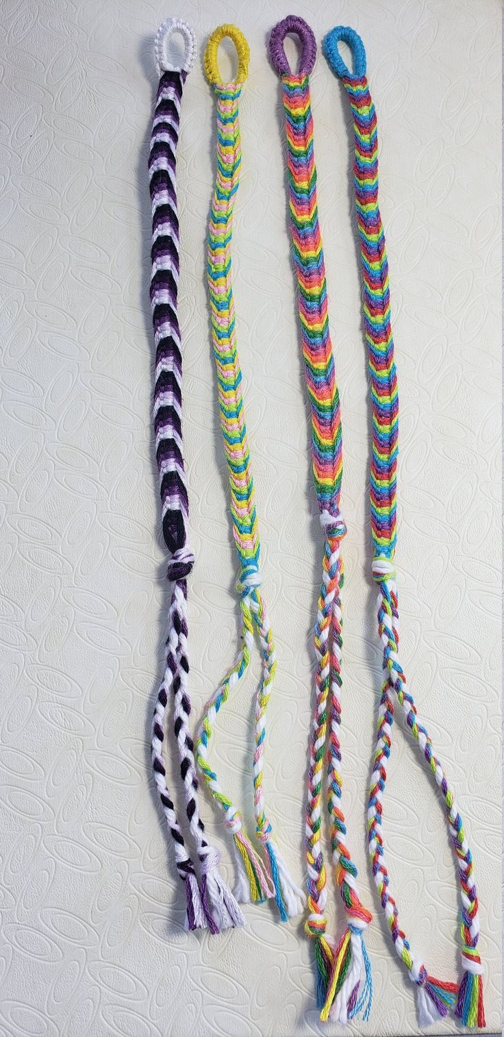 four different colored ropes are lined up on a white surface