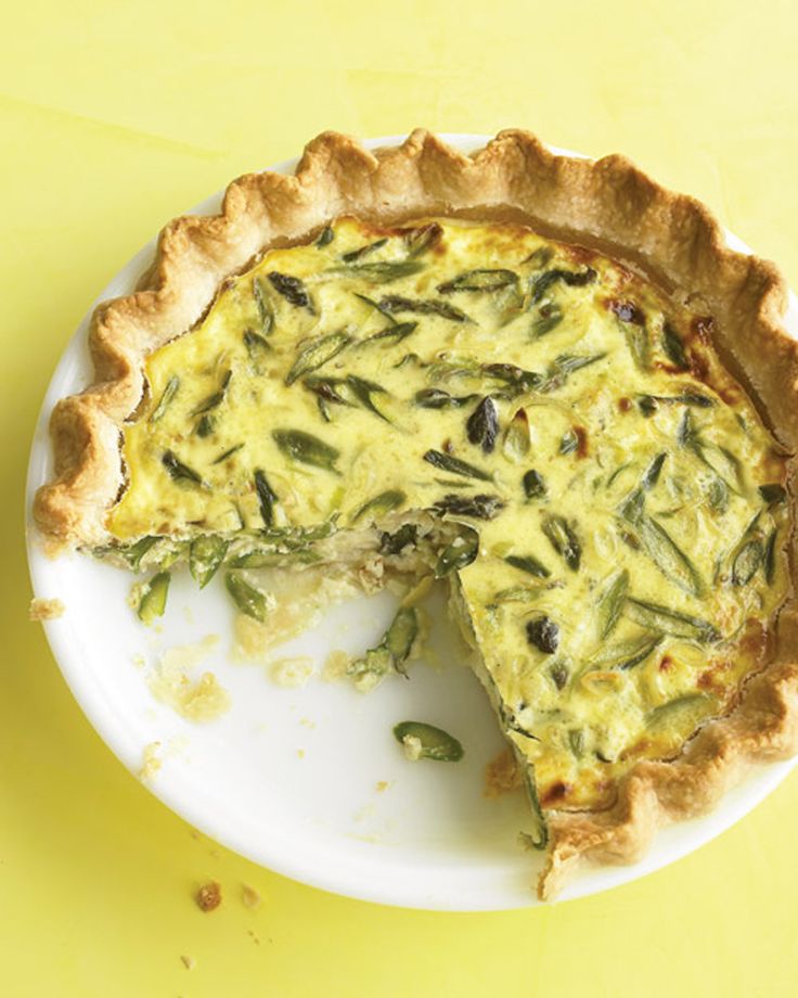 a quiche on a plate with one slice missing