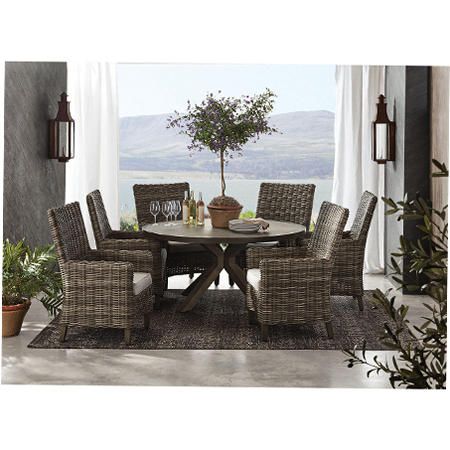 a dining room table with chairs and a potted plant in the corner next to it