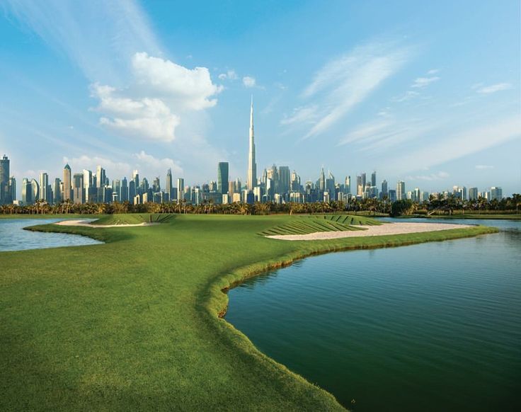 a golf course in the middle of a city with skyscrapers and buildings behind it