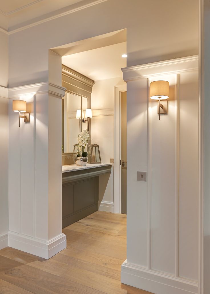 an open door leading into a bathroom with wood flooring and white trim on the walls