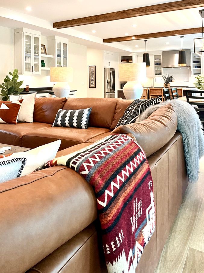 a living room filled with lots of furniture and decor on top of wooden flooring