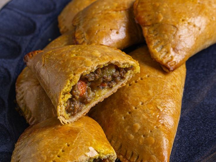 several pieces of meat filled pastries on a blue plate