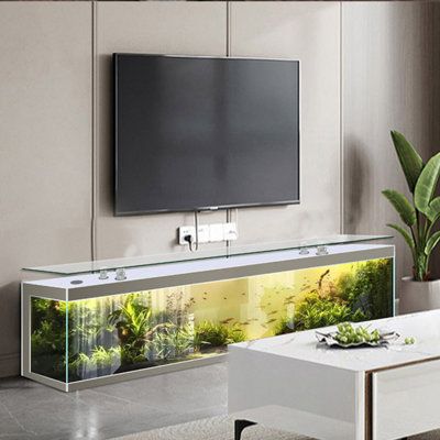 a fish tank sitting on top of a white table in front of a flat screen tv