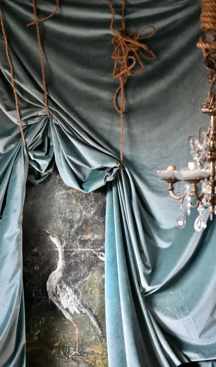 a room with blue drapes and a chandelier