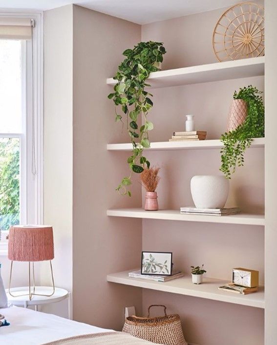 a bed room with a neatly made bed and shelves