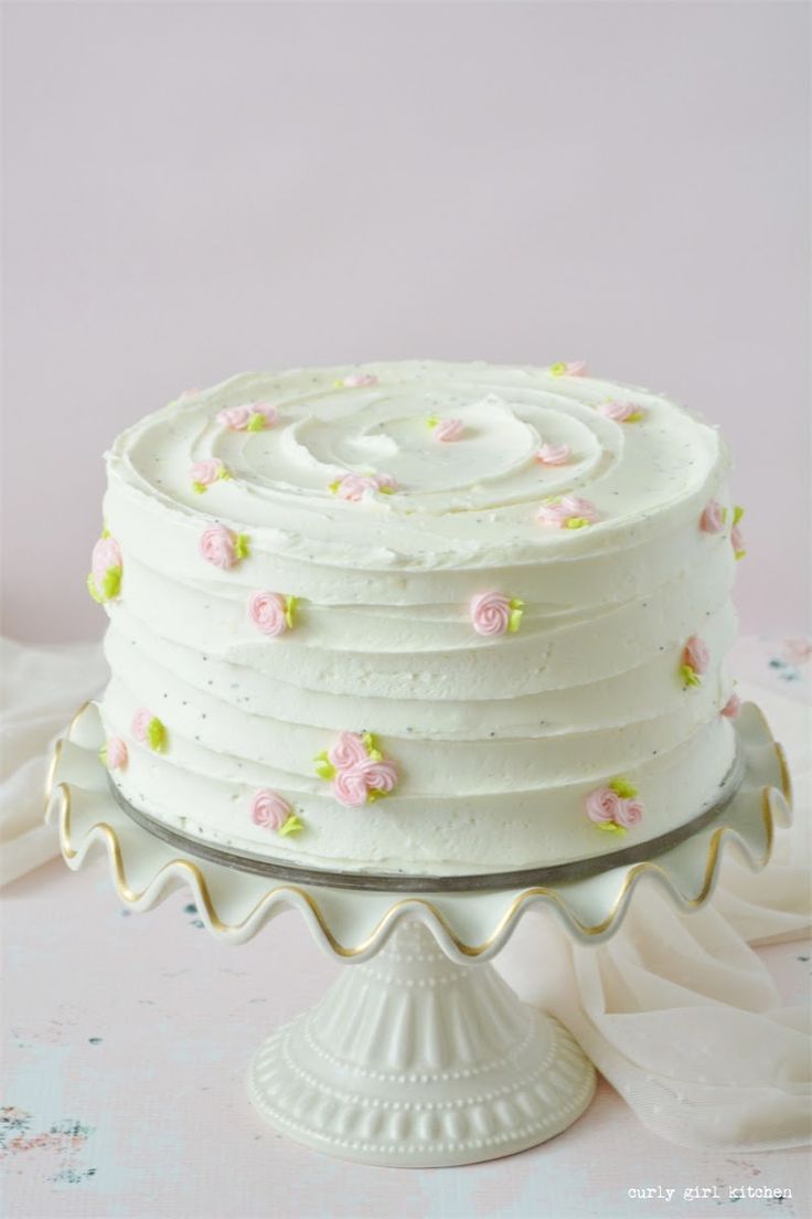 a white frosted cake with pink flowers on it