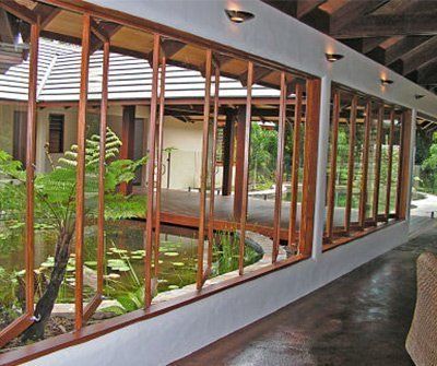 the inside of a house with lots of windows and plants in it's yard