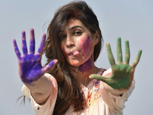 a woman with her hands painted in purple and green