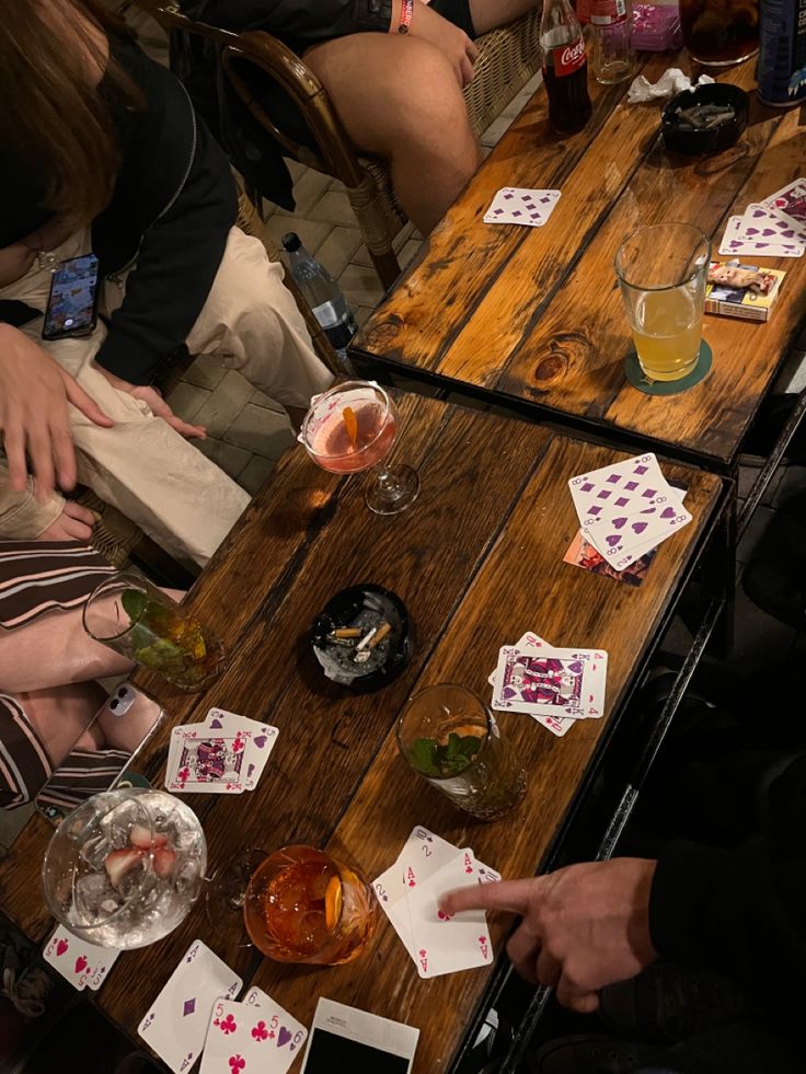 several people sitting at a table playing cards