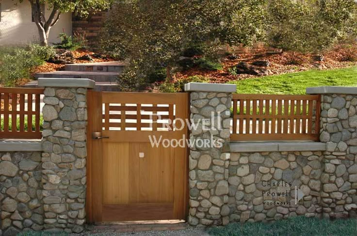 a stone wall with a wooden gate in front of it