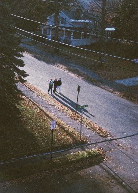 two people are walking down the street in front of some power lines and telephone poles