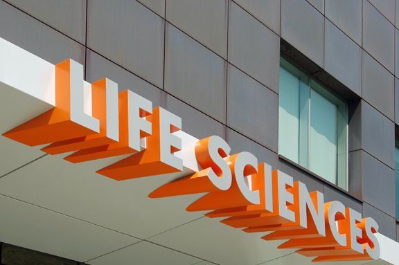 an orange and white sign that says life science's on the side of a building