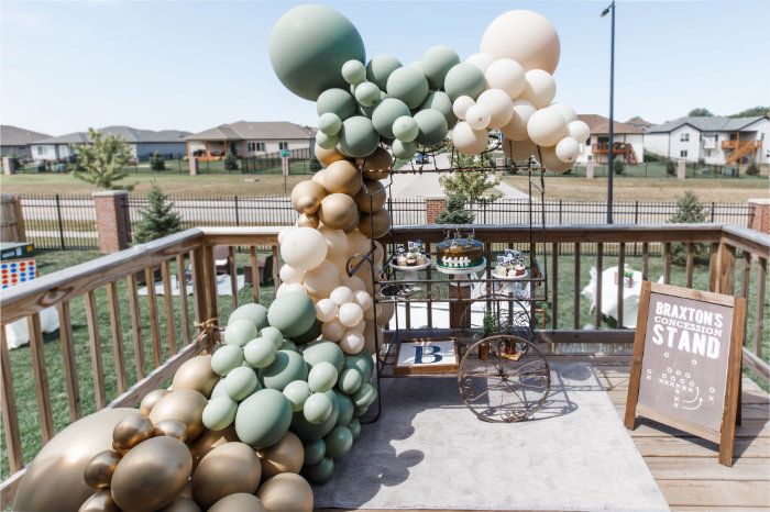 an outdoor table with balloons on it