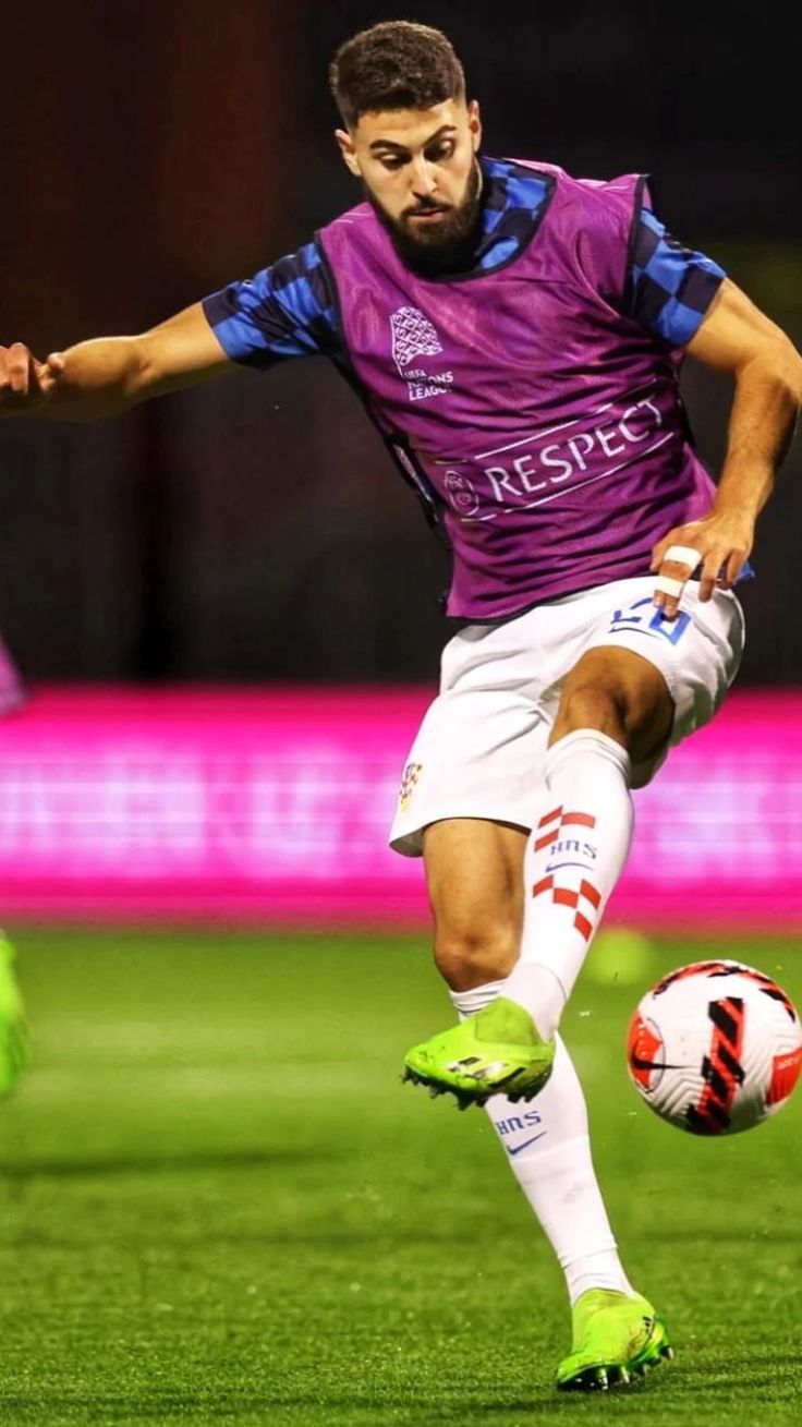 a man kicking a soccer ball on top of a field