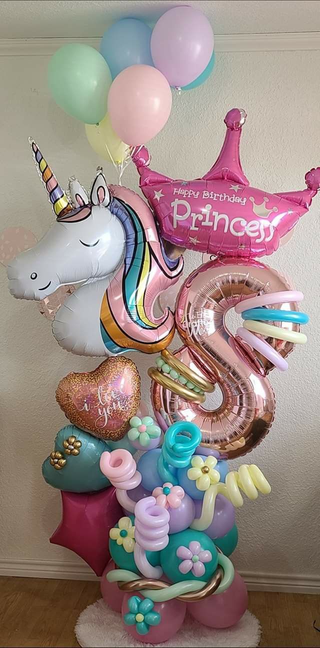 a bunch of balloons that are in the shape of animals and unicorns on top of each other