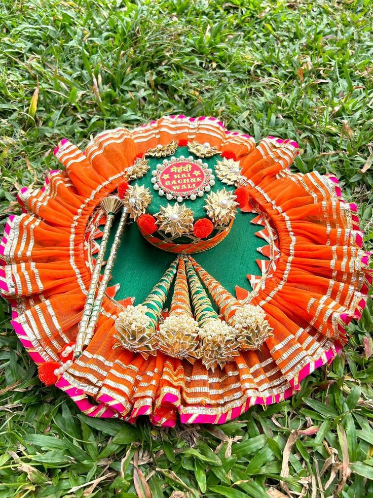 an orange and green fan laying in the grass