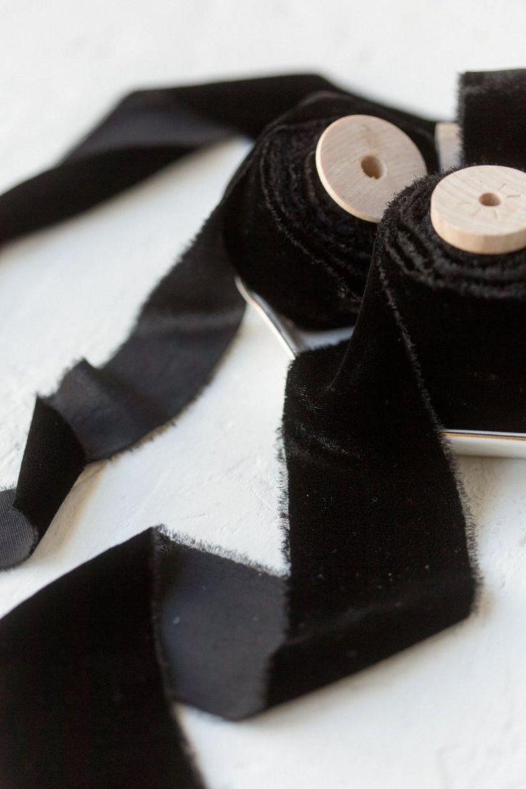 black ribbon with wooden buttons on white surface