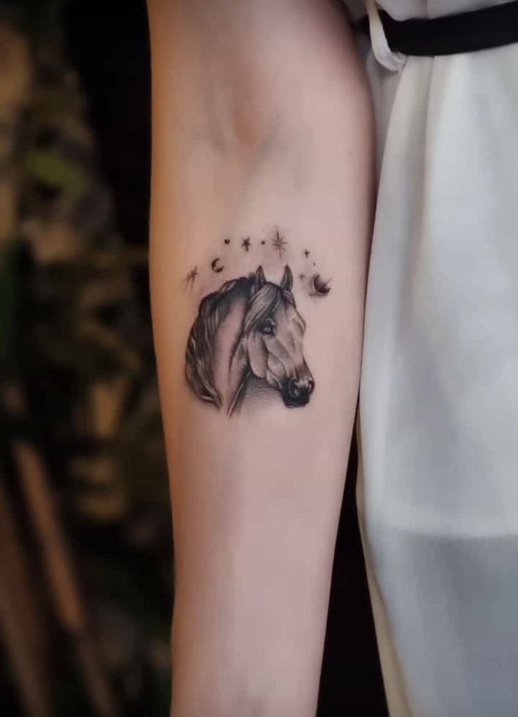 a woman's arm with a horse tattoo on the left side of her body