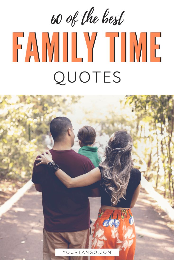 a man and woman are holding their son's arms as they walk down the road