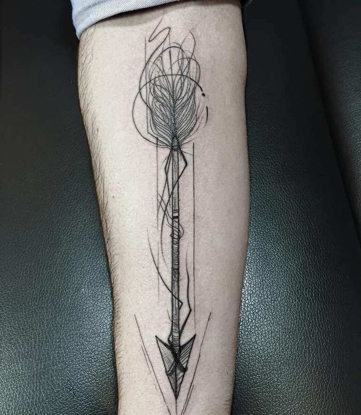 a man's leg with an arrow and compass tattoo on the side of his leg