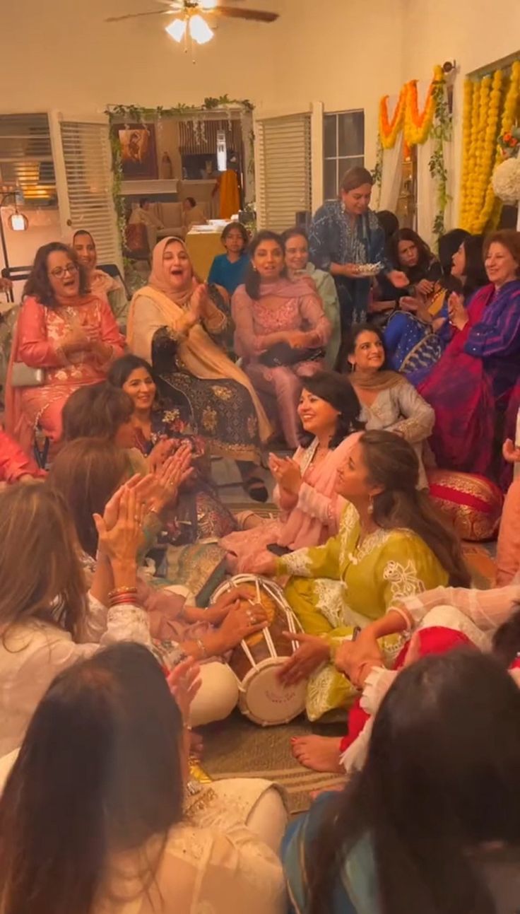 a group of people sitting on the floor in front of each other with their hands up