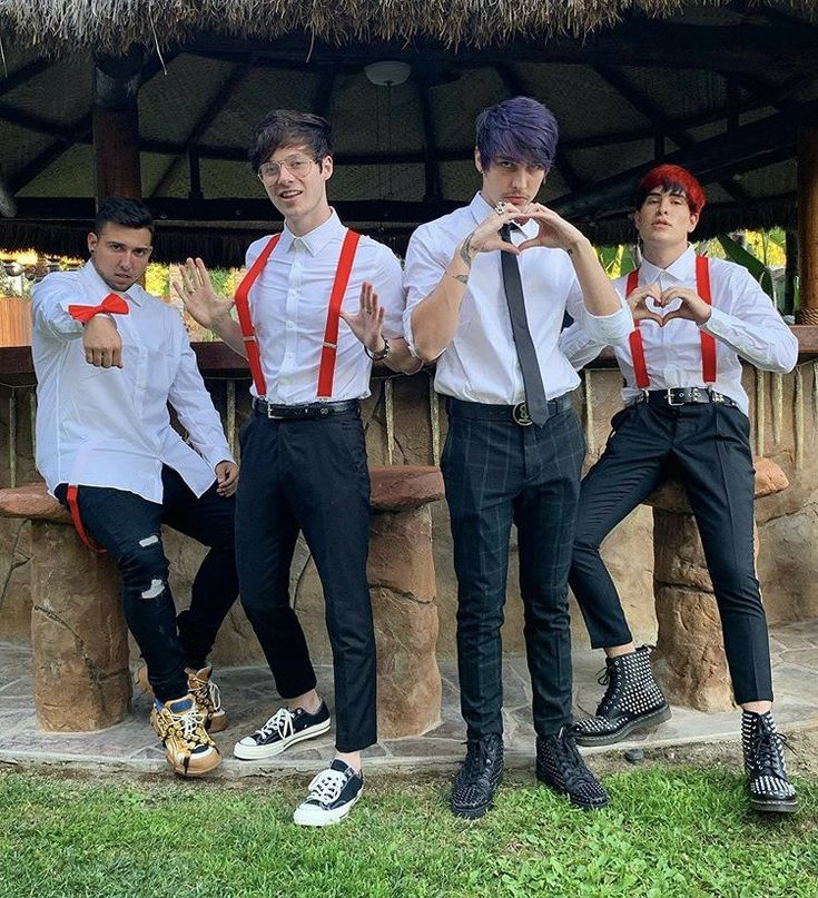 four young men wearing suspenders and ties posing in front of a tiki hut